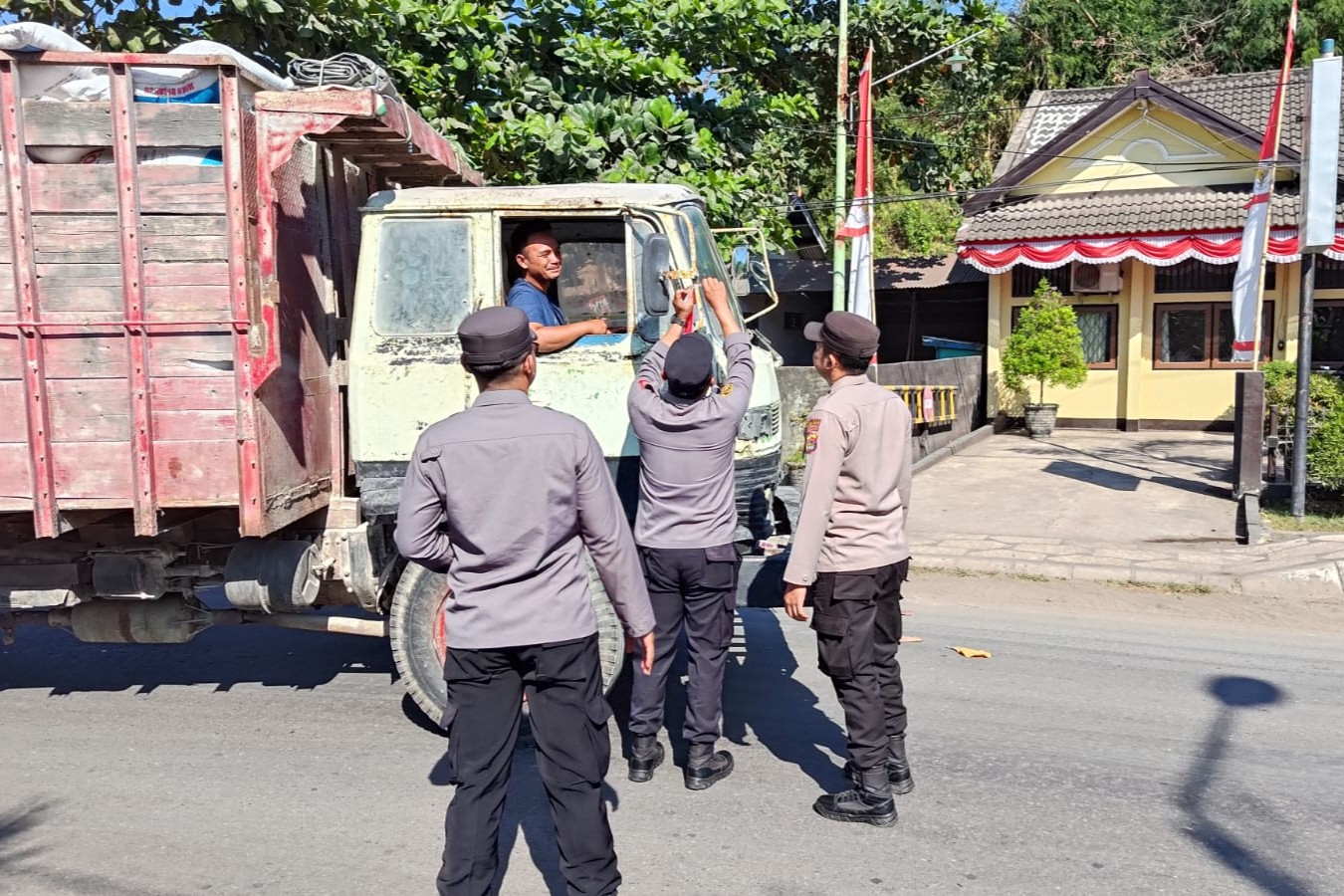 Polsek Pelabuhan Lembar Bagikan Bendera Merah Putih kepada Sopir Truk Sambut HUT RI ke-80